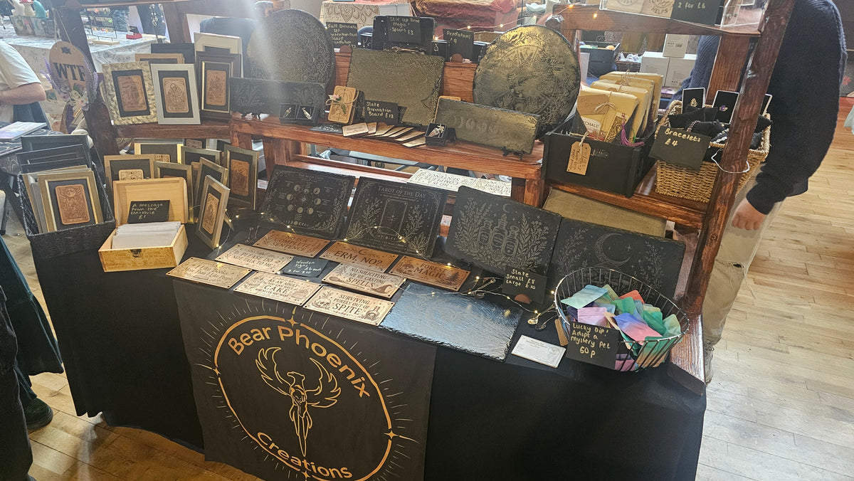 A layered display of Bear Phoenix Creations framed cards, signs and engraved pieces