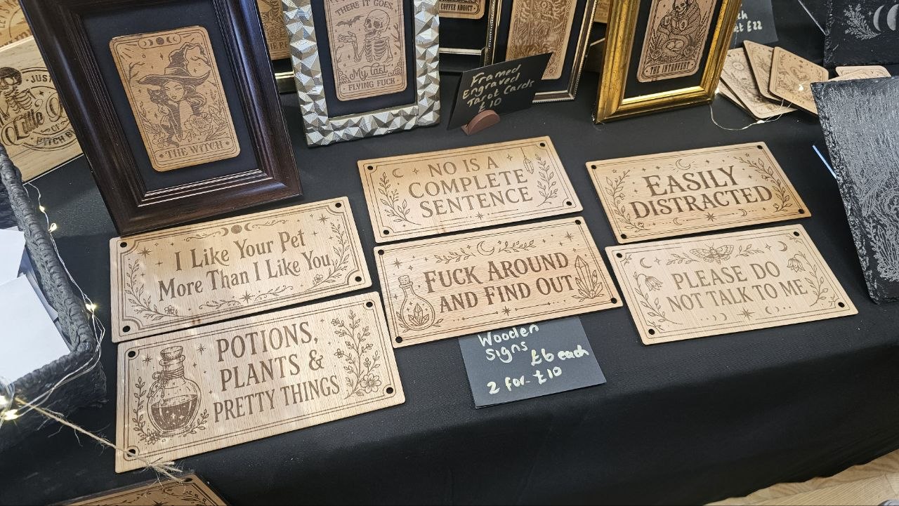 Close-up of engraved wooden signs on the Bear Phoenix Creations stall